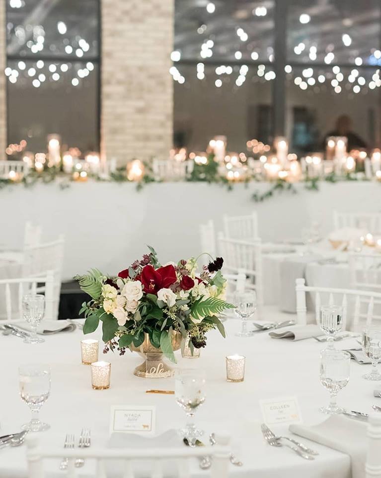 Rooftop bar with white tablecloth and red flower  centerpiece