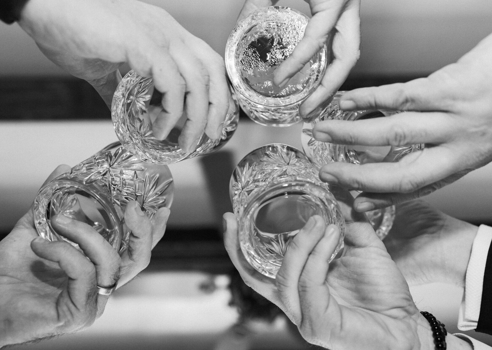 Close-up of wedding guests toasting with crystal glasses at Baker's Cay, captured by Claudia Amalia, a wedding photographer in Miami.