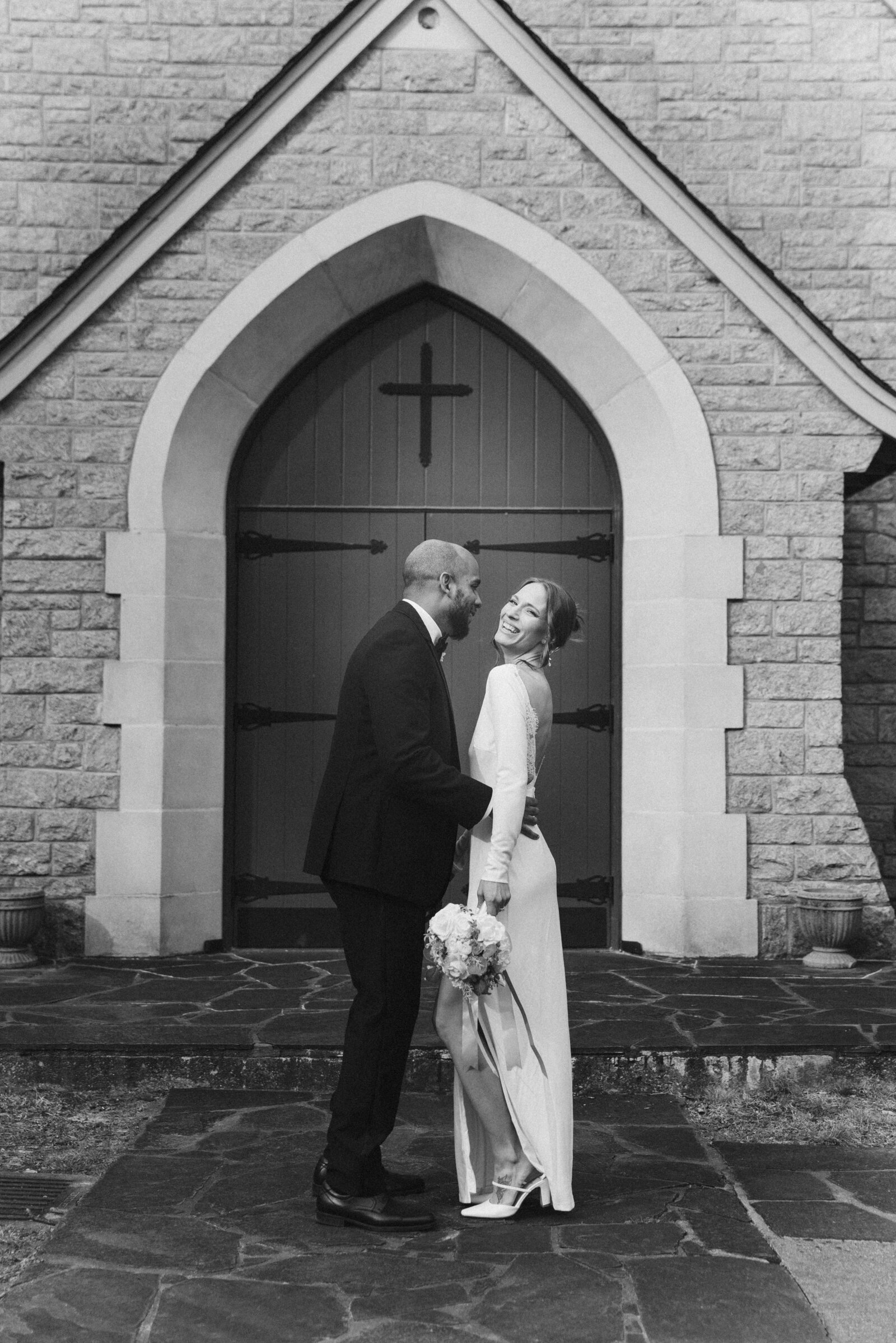 moody black and white image of a small wedding bride and groom 