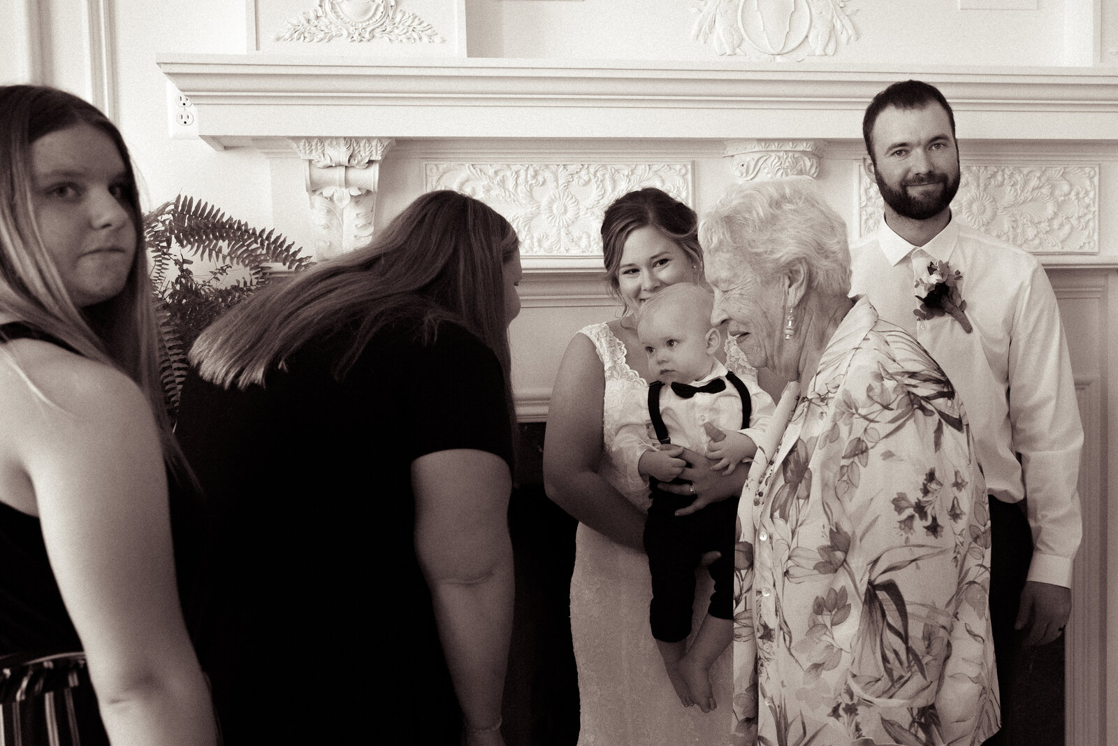 capture of bride looking at grandma looking at baby looking at groom
