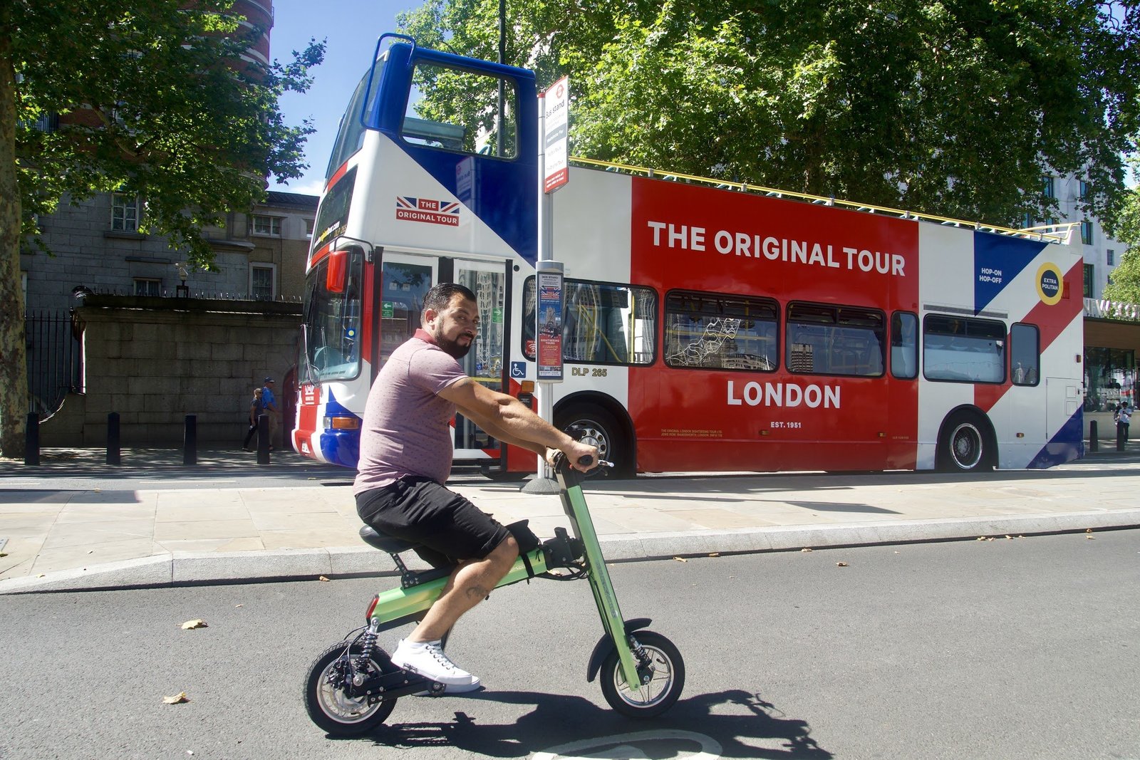 Man cruising the streets of London with UK bus in the background