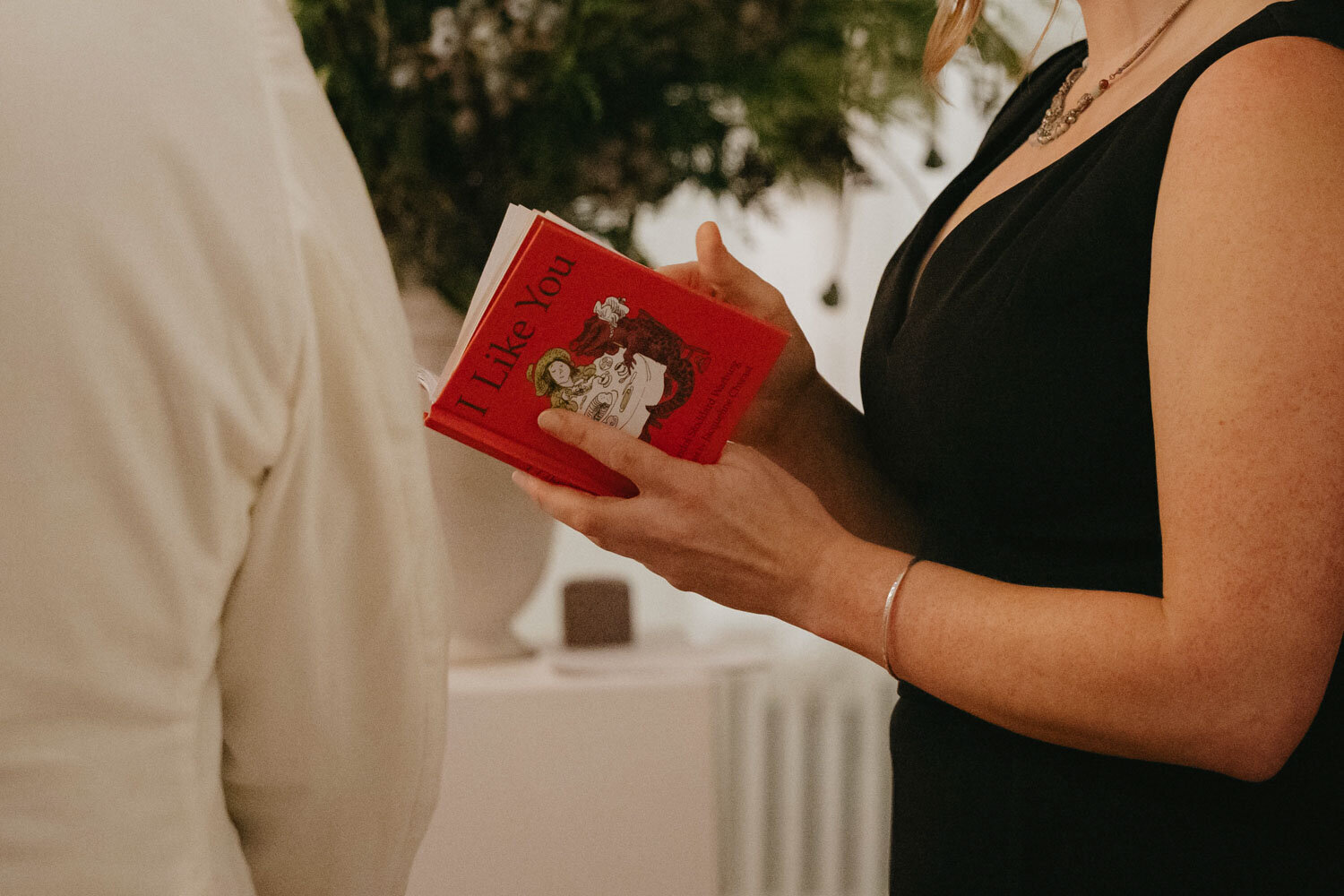 Close up photo of a woman holding red little notebook