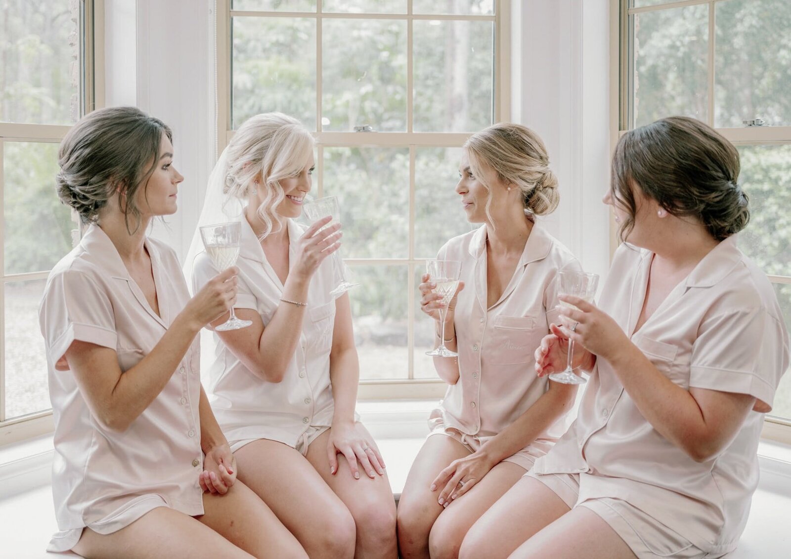 Bride and bridesmaids drinking champagne