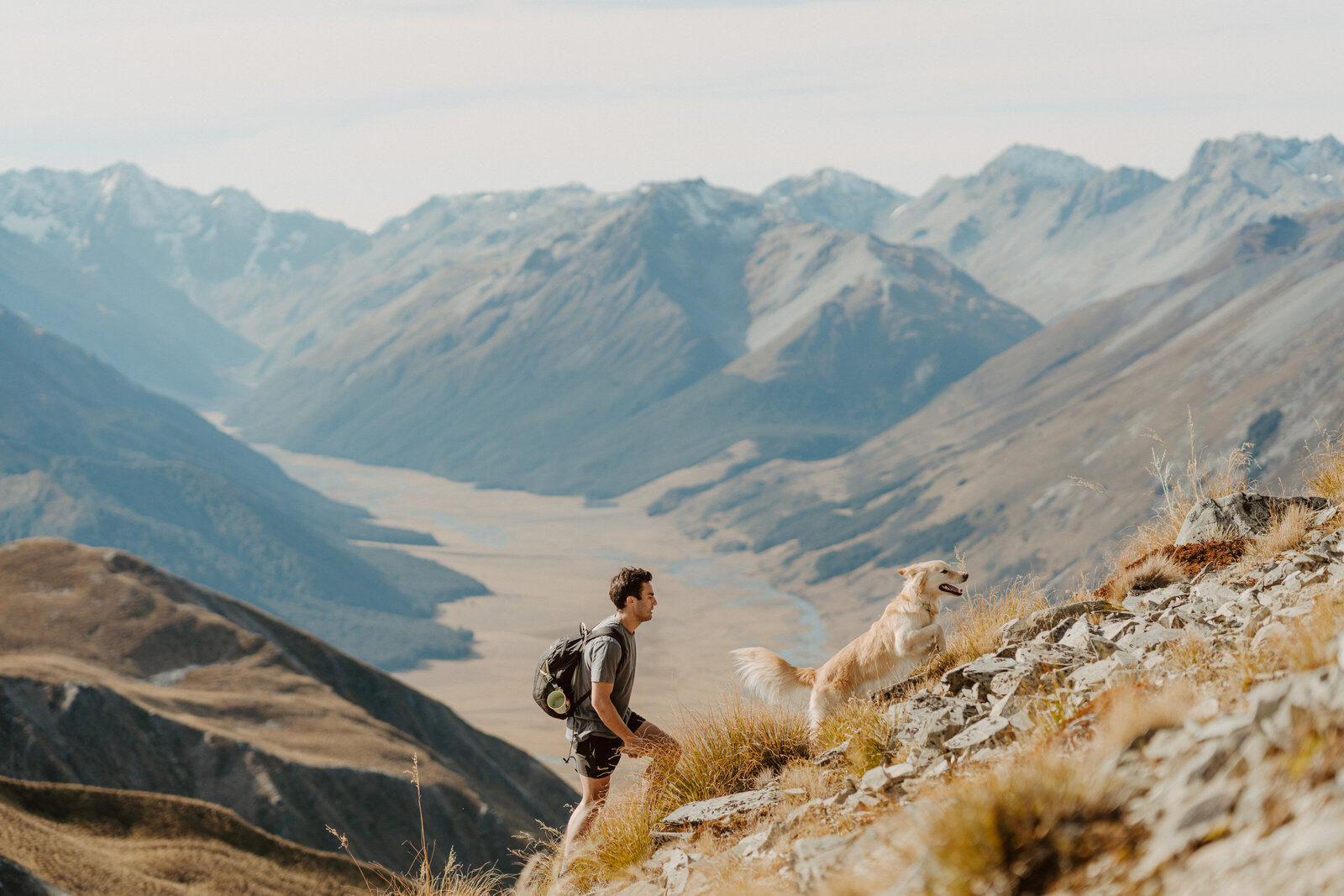 man-and-dog-running-up-mountain