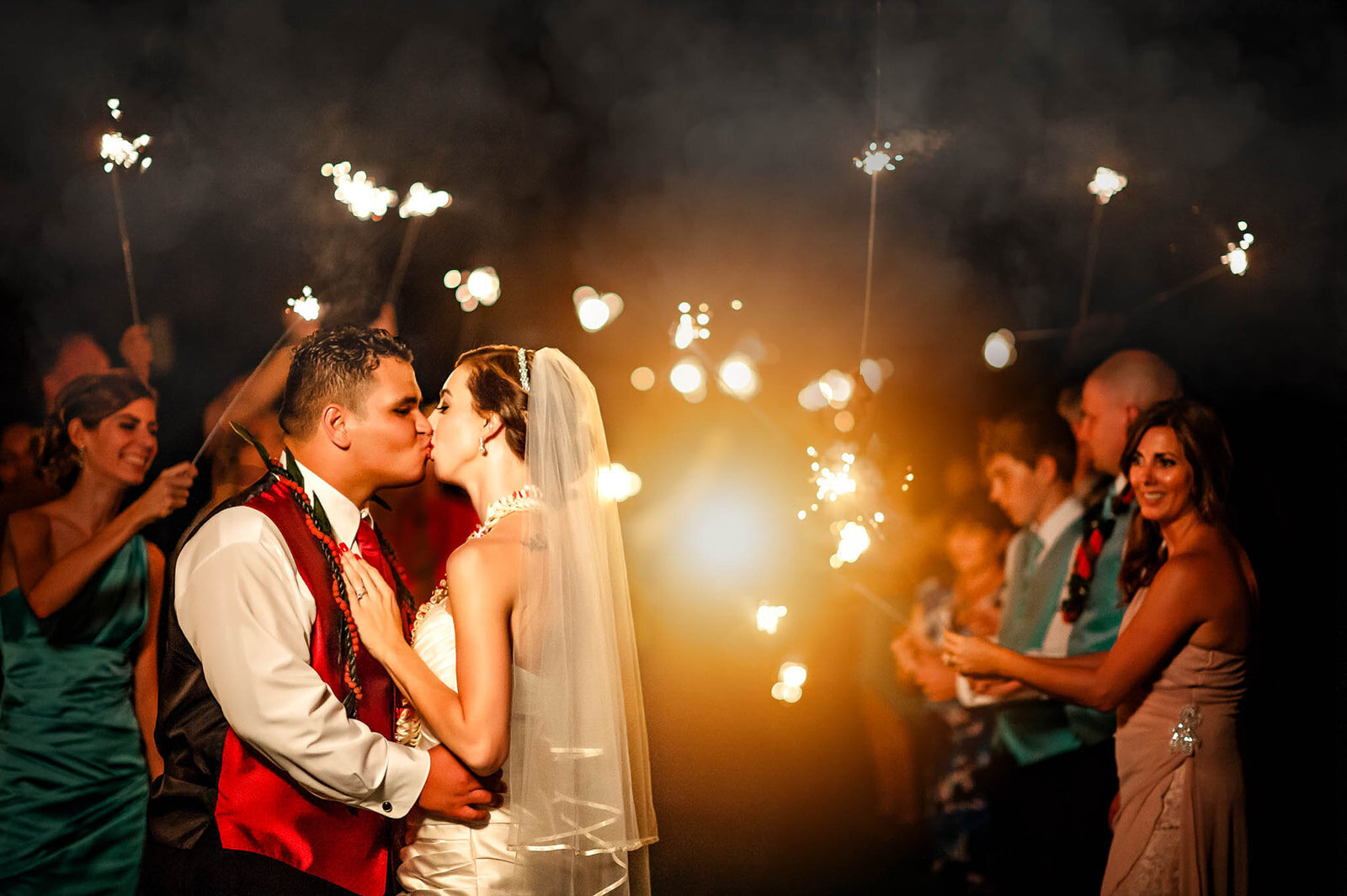 A joyous sparkler exit as the bride and groom are surrounded by loved ones, captured during a San Antonio wedding by CMH Studios