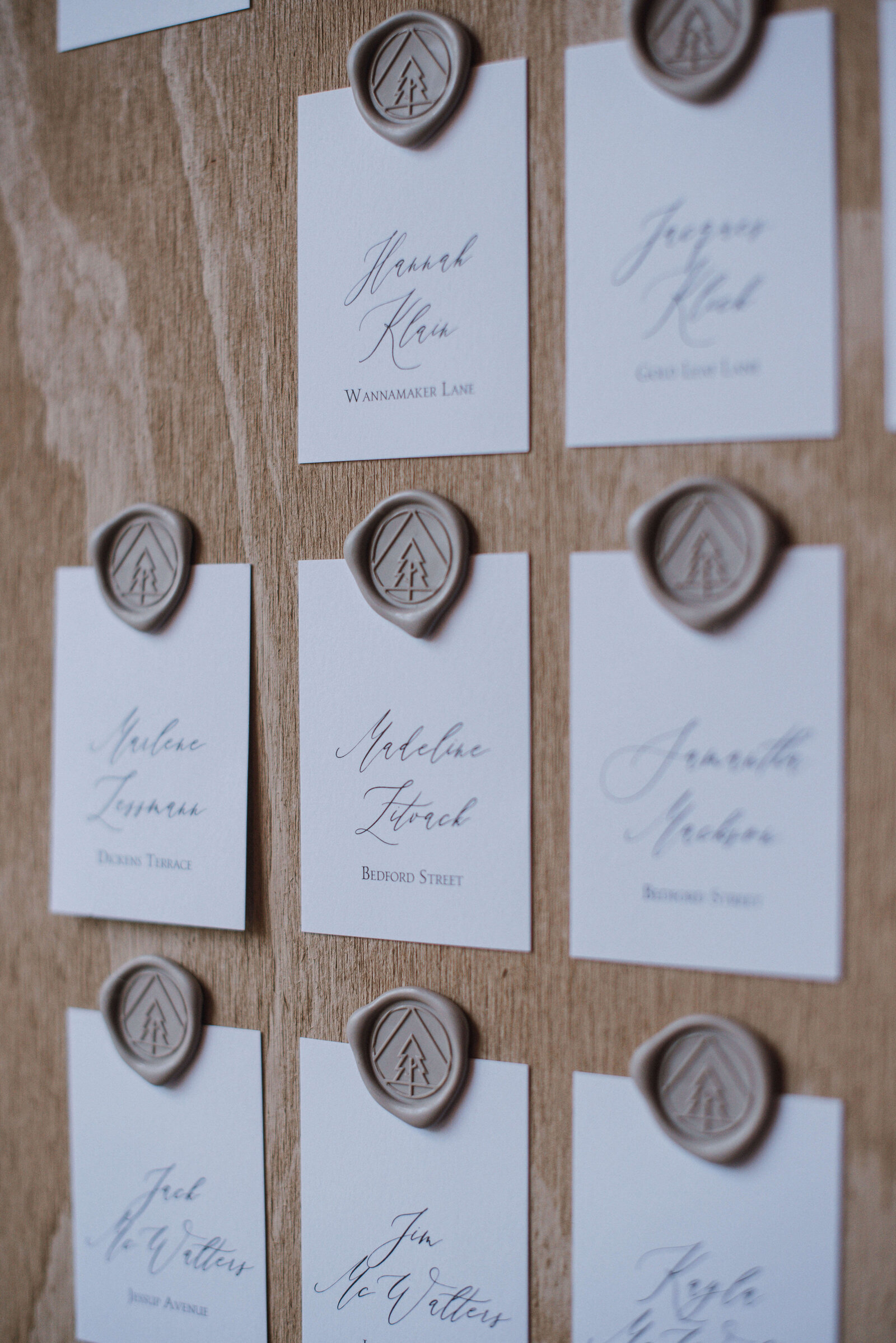A wedding seating chart with wax seals of trees and mountains