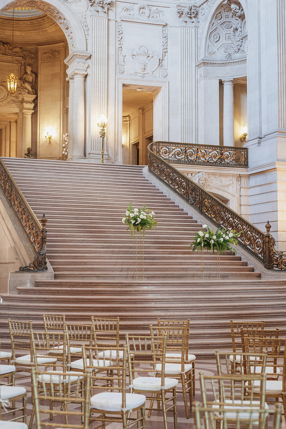 Grand and elegant wedding staircase with florals visible