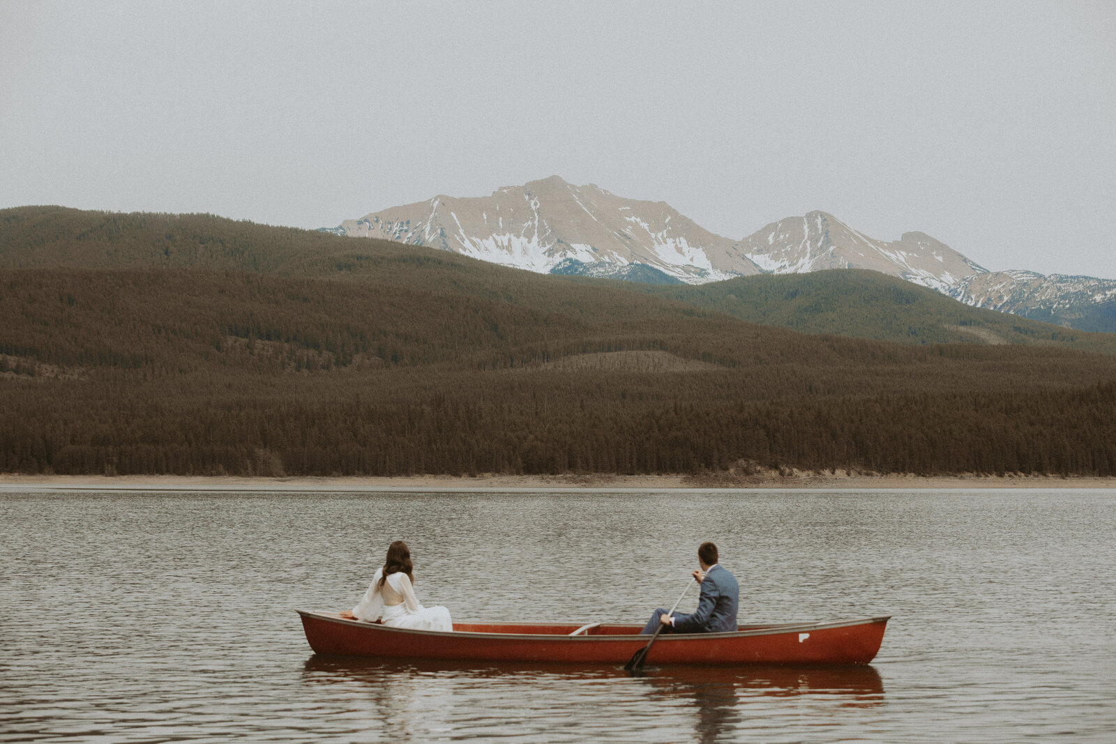 elopement photo of couple sitting in canoe in glacier national park