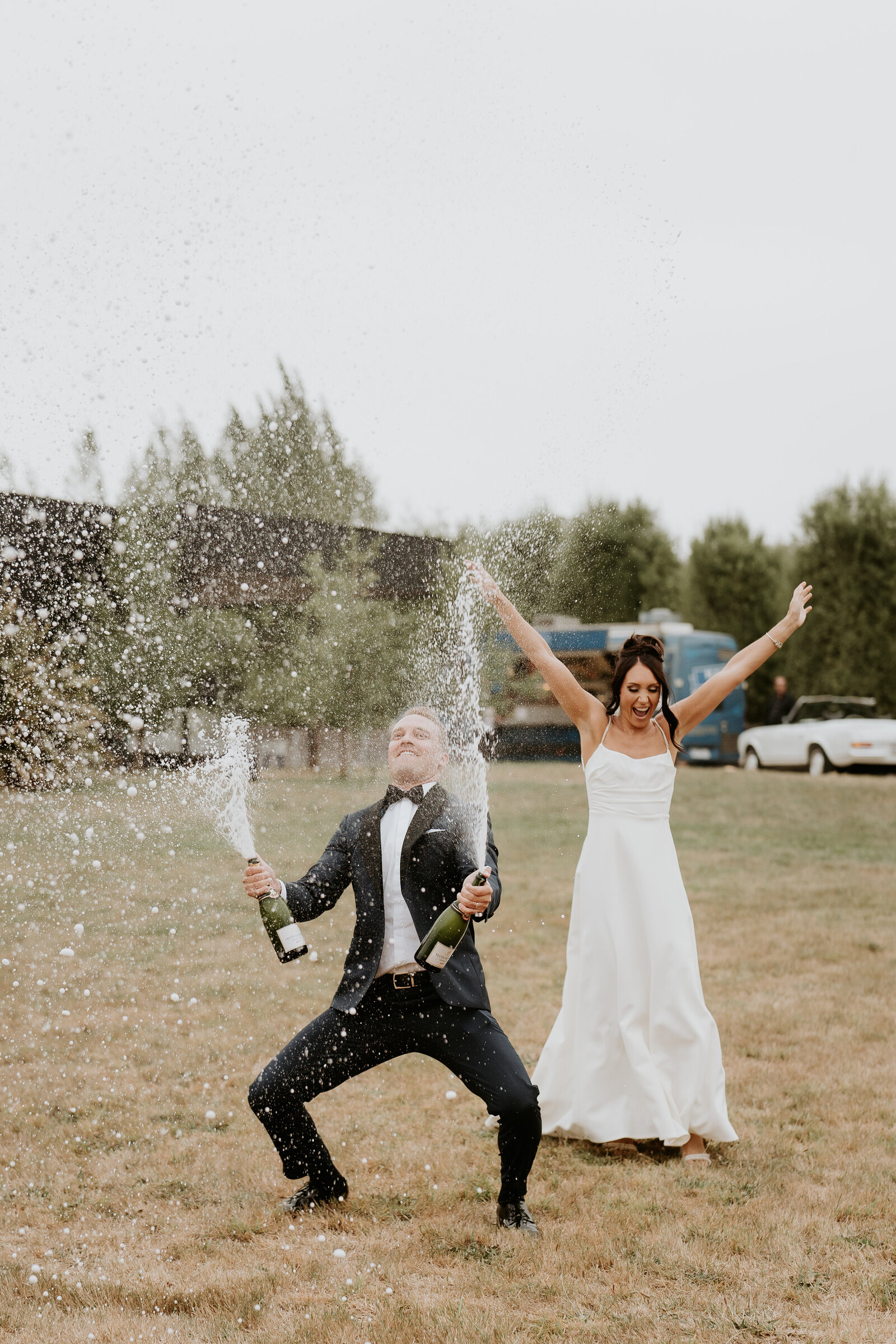 Bride and groom entering reception while spraying champagne 