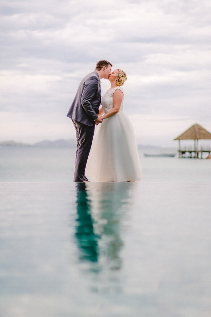 couple kissing on the edge of an infinity pool