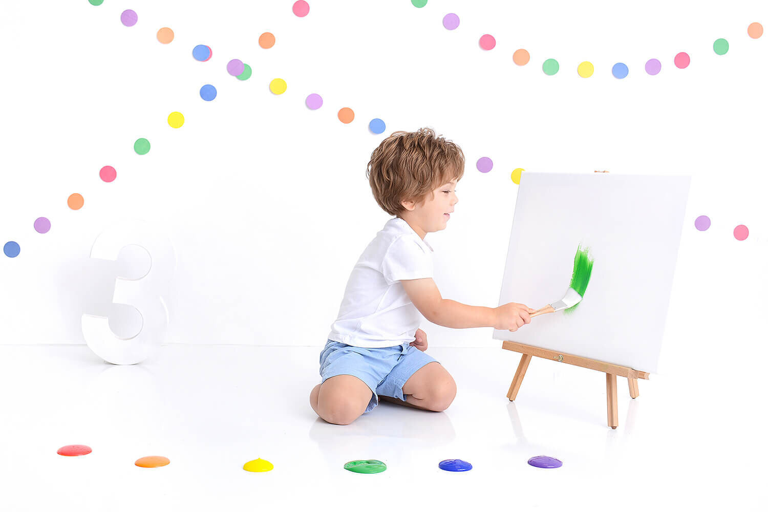 boy paints a canvas at his 3rd birthday photosession
