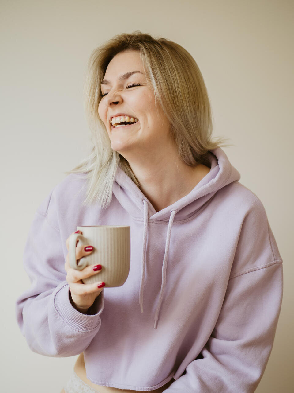 Frau in Oversize-Pulli, entspanntes Boudoir-Foto mit natürlichem Ausdruck