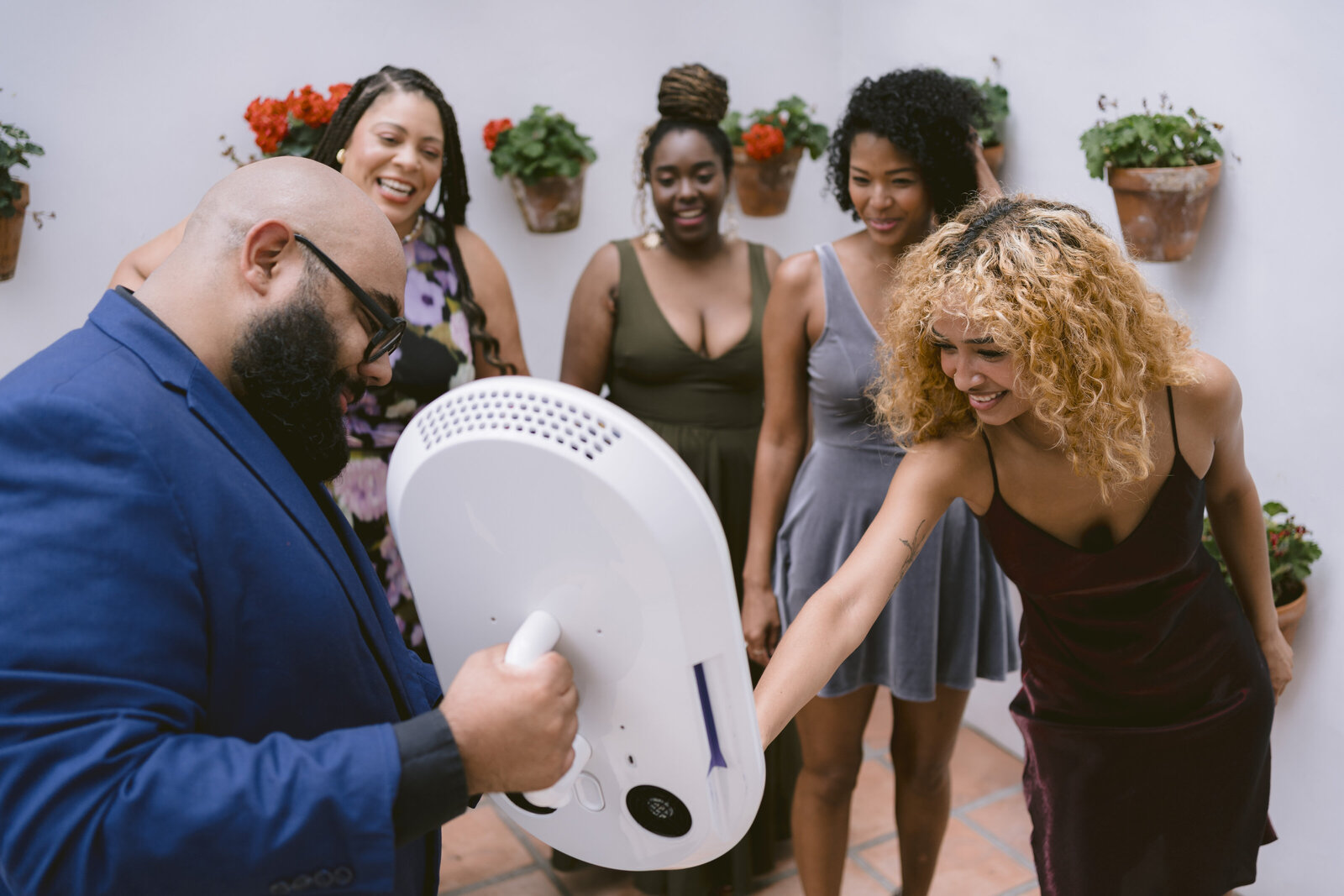 Photo booth attendant using the handheld roamer booth to capture candid guest moments on the dance floor