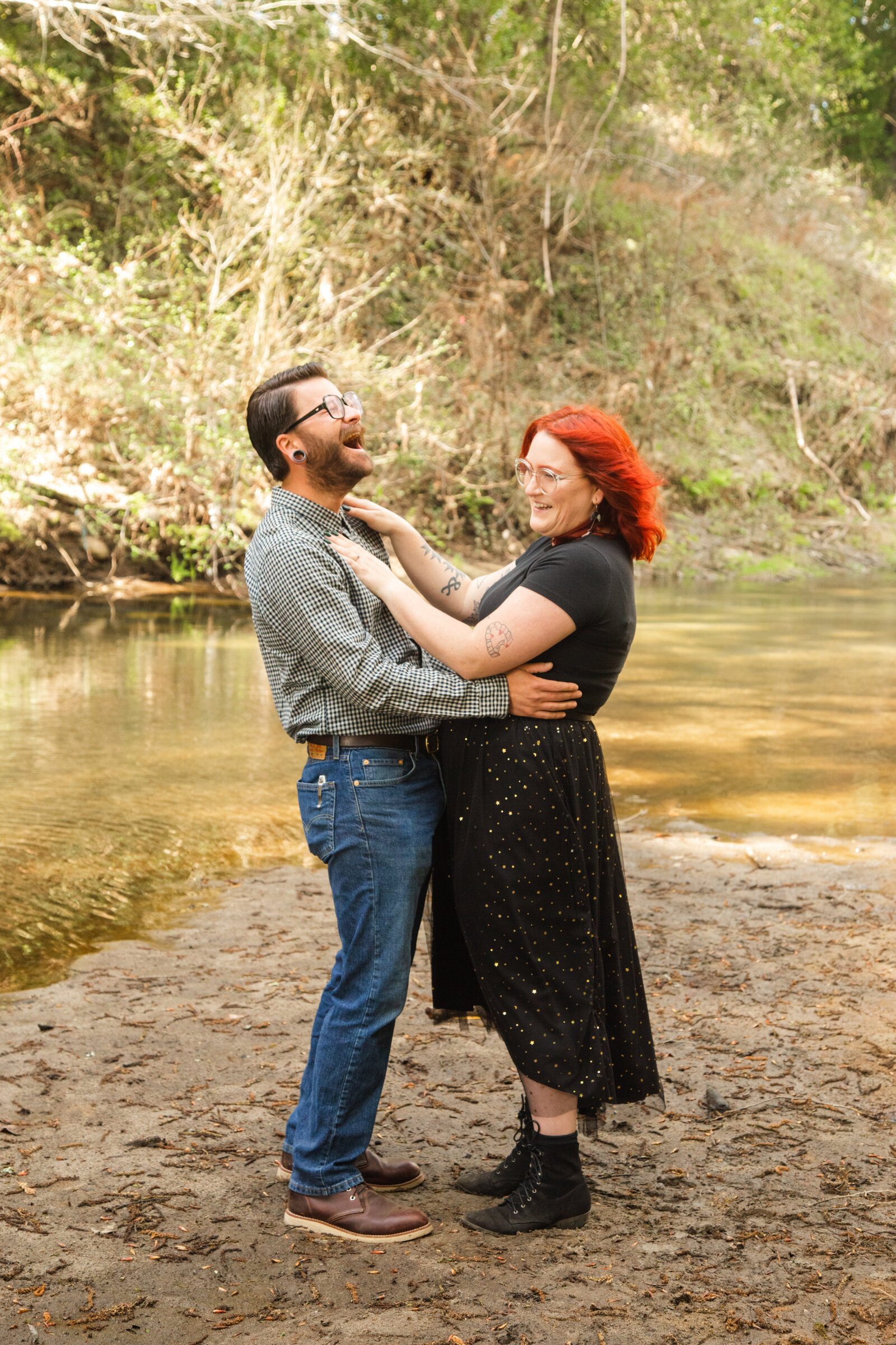 An tattooed engaged couple poses for photos in a redwood forest in Santa Cruz, Ca.