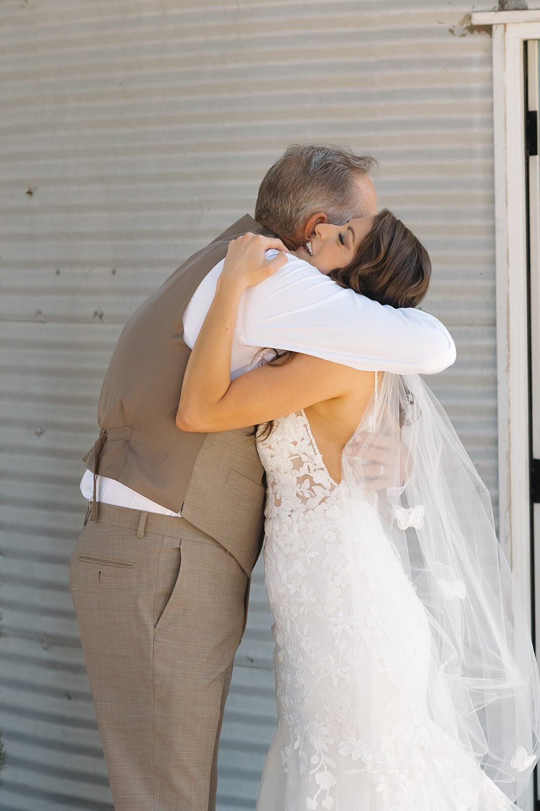 Bride hugging her dad during their first look by the silo