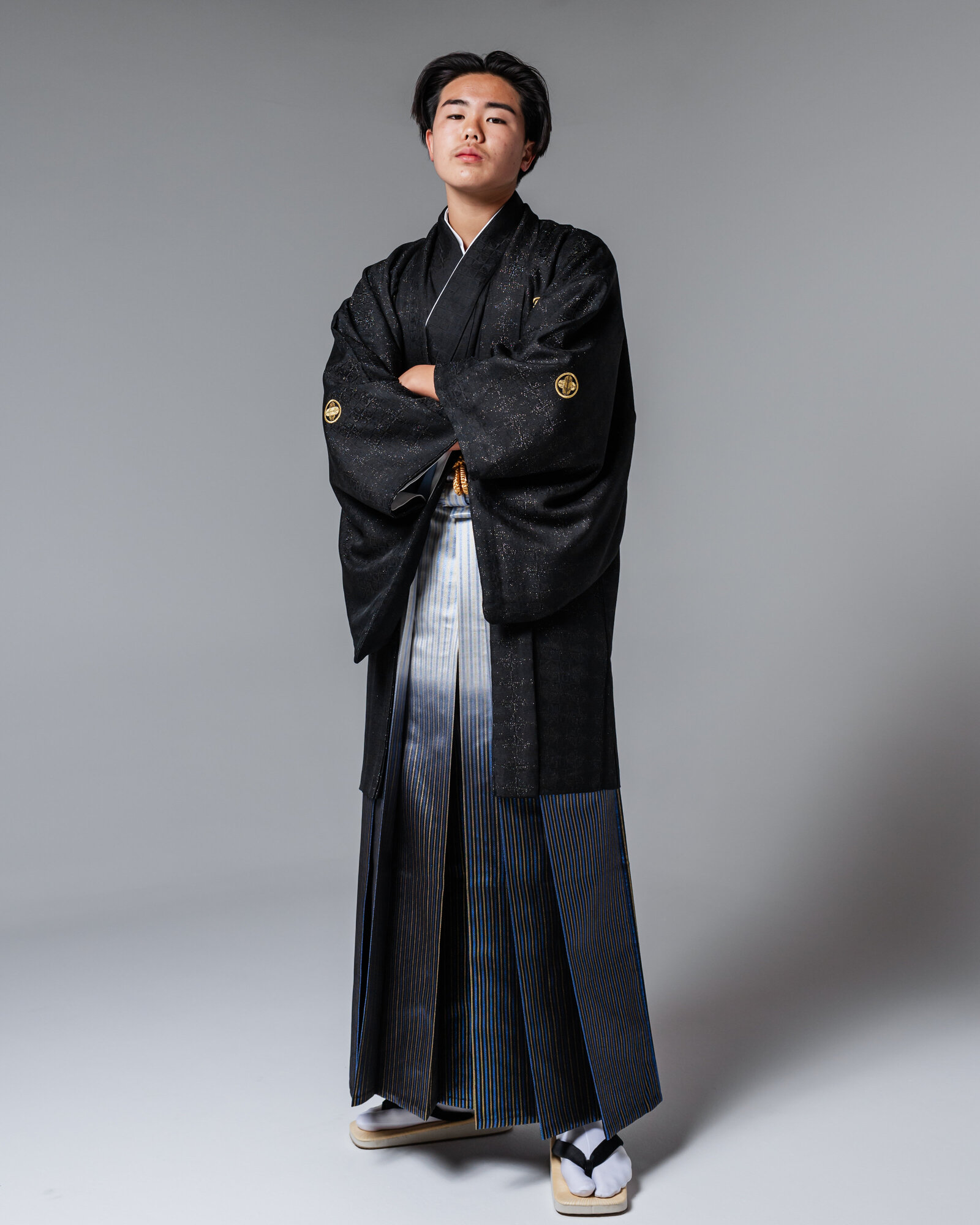 Boy in full-length black montsuki hakama standing with arms crossed for graduation | 卒業式 黒紋付袴 男の子 全身ポートレート