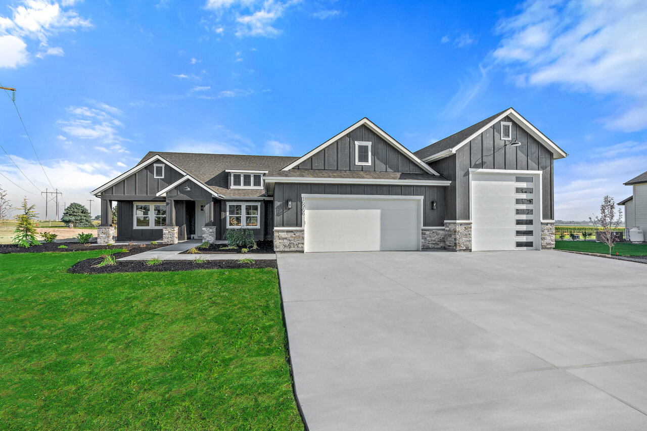 new home on quiet street gray house with white garage doors