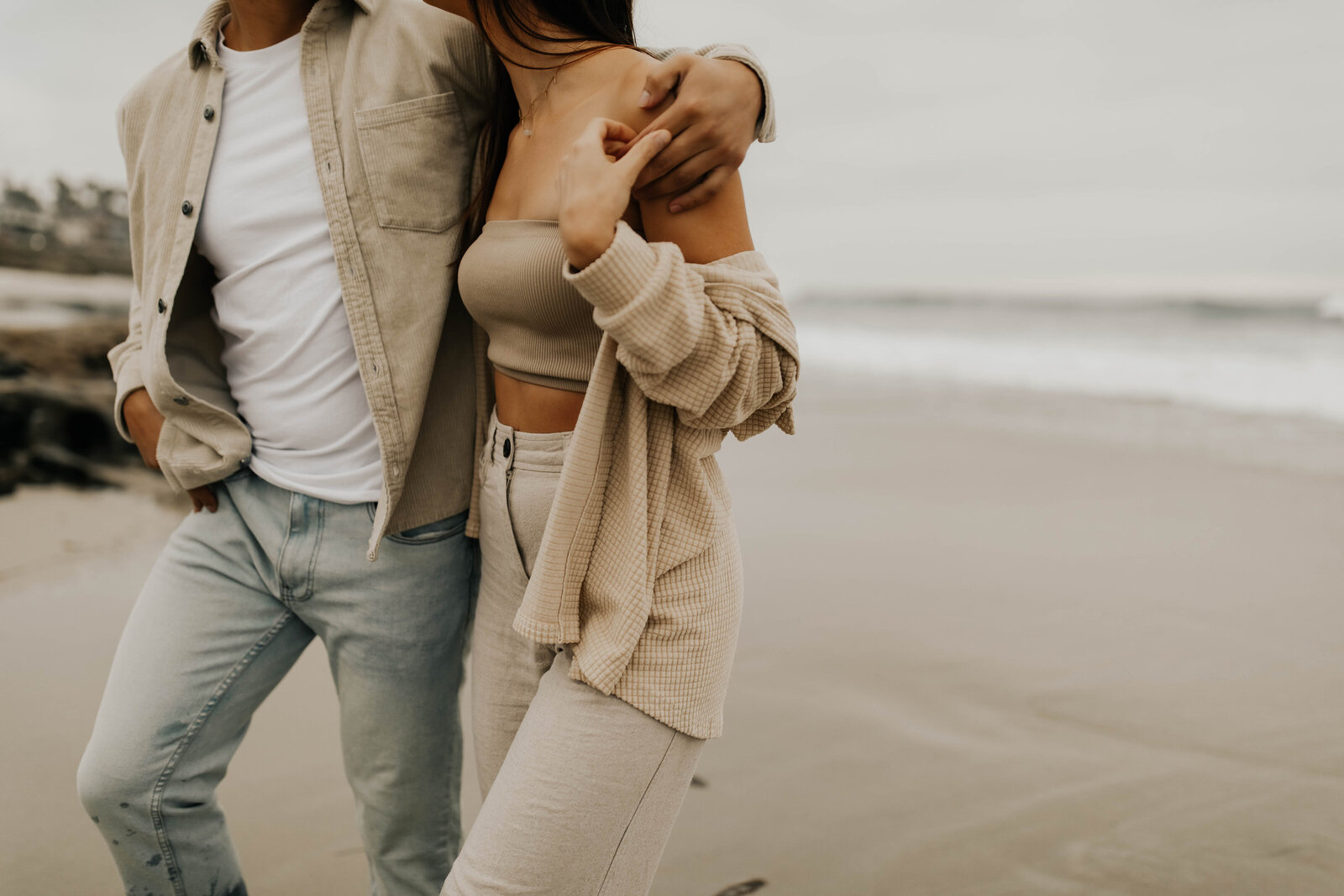 close up of man and woman walking on beach