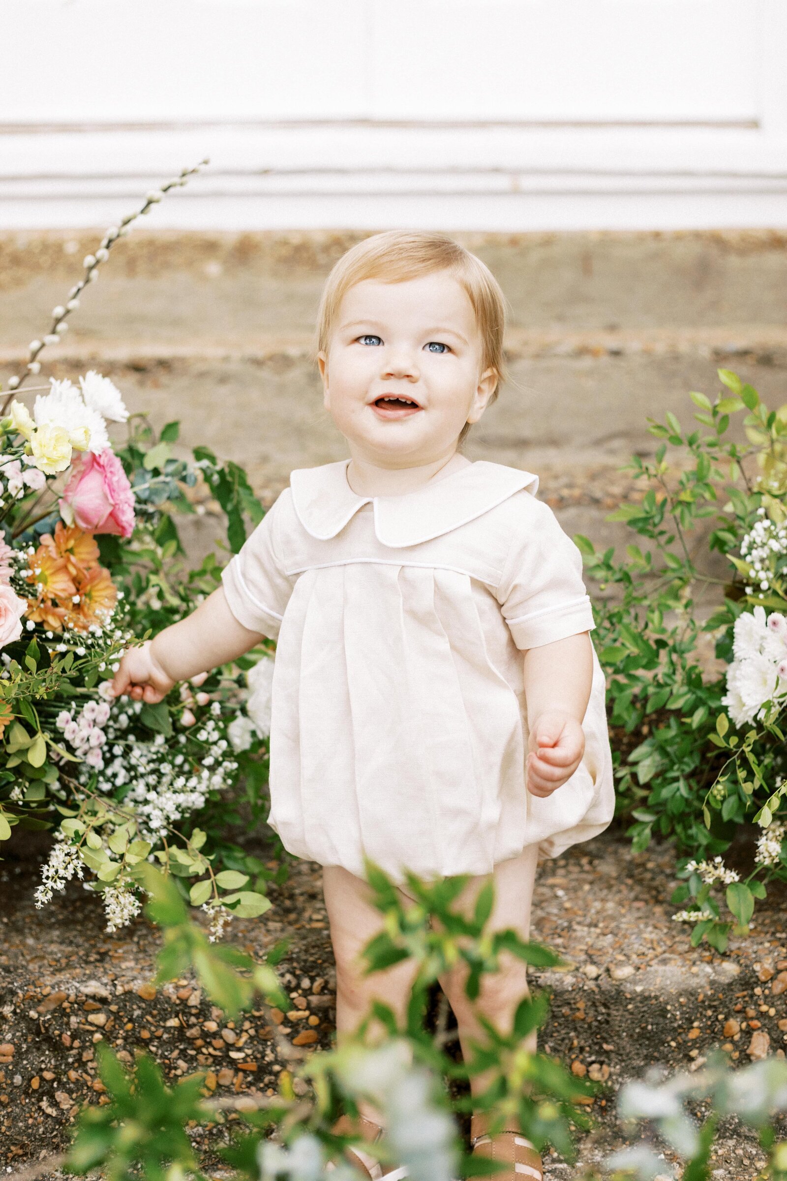 baby in smocked outfit smiling during peoria illinois family photos 
