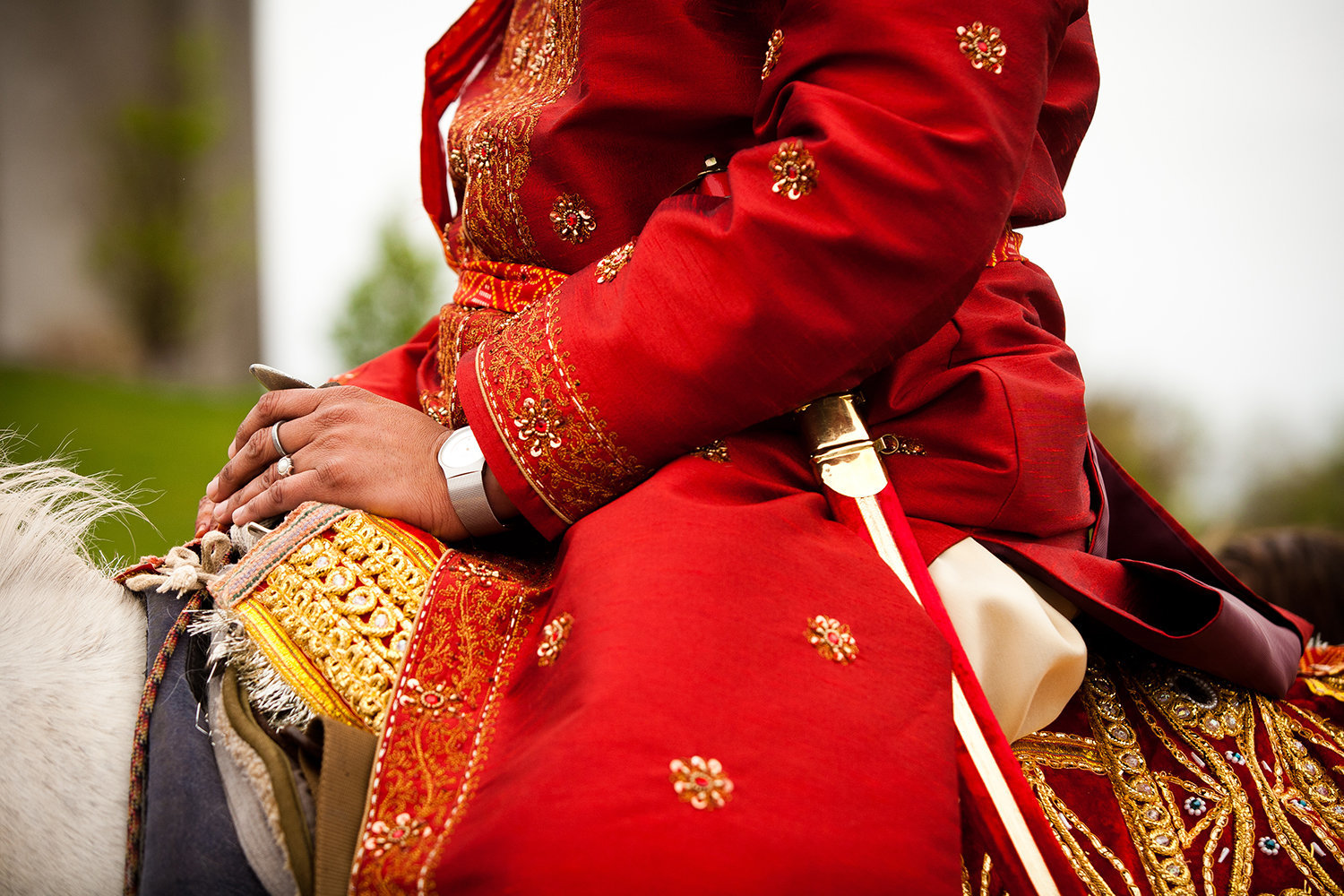 Close up of groom on horseback with sword during Hindu Baraat ceremony