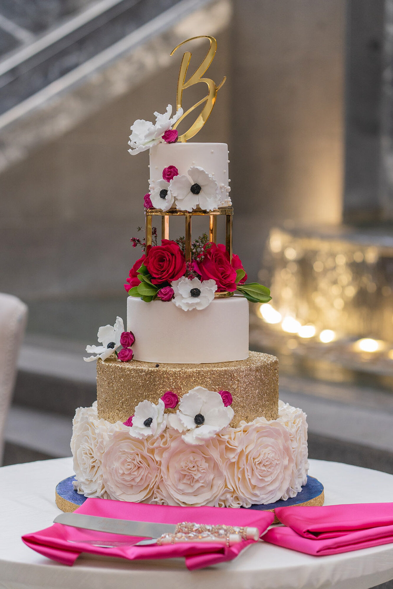 luxury wedding tier cake at wedding reception with gold and pink details