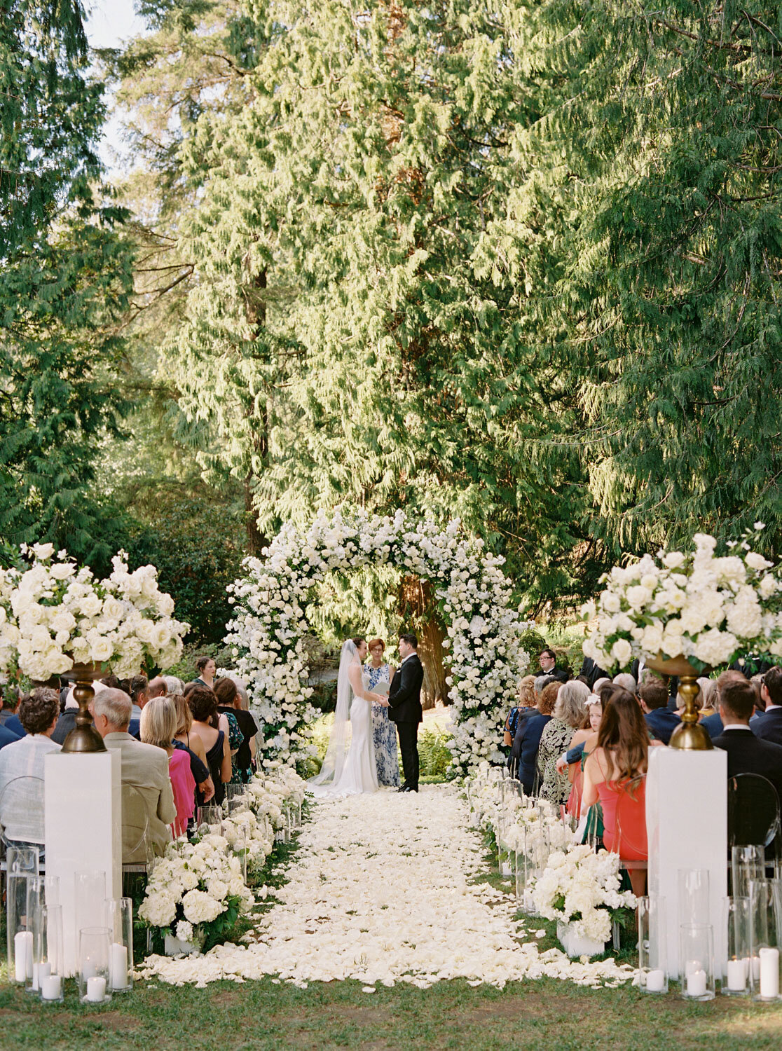 Outdoor wedding ceremony with floral arch and aisle