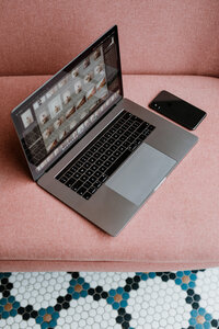 kaboompics_macbook-pro-laptop-iphone-x-mobile-on-a-pink-sofa-10060