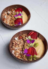 fallback shared on Invalid Date | Two breakfast bowls brimming with smoothie, granola, fresh fruits, and edible flowers, c...