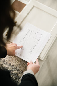fallback shared on Invalid Date | A woman holds a printed floor plan and points to the dining room