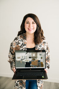 fallback shared on Invalid Date | A woman holds her laptop showing a digital rendering of a modern living room