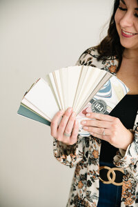 fallback shared on Invalid Date | A woman holding paint color swatches