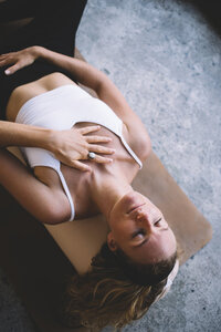 relaxed-woman-lying-on-mat-on-marble-floor-2024-05-08-17-08-47-utc