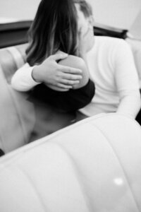 black and white engagement photo of future bride and groom hugging in a car