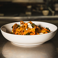 Steak filet bites with criminis, black kale, sweet bell peppers, bleu cheese, smoked tomato sauce Max Dales Steak and Chop House Restaurant