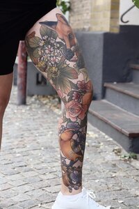 Neotraditional tatuering av djur och växter på hela benet.