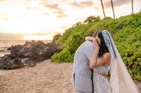 Maui Elopement Photographer captures couple embracing on beach after intimate hawaii beach wedding