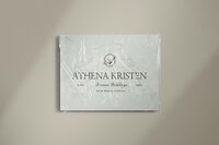 Elegant Athena Kristen Dream Weddings logo on soft floral stationery, wrapped in clear packaging—refined branding design for luxury wedding planners in Palm Beach, Florida.
