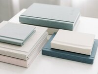 A stack of blue and white albums on a white table.