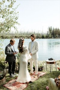 Woman pouring champagne into a glass while sitting on a mans lap.