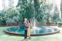 bride and groom standing at the fountain