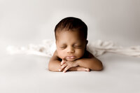 newborn boy sleeps in creamy neutral colors in studio located near Birmingham