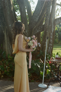 Yellow silk bridesmaid dress with pink and cream florals at a beach wedding in South Florida | SushDigitalMedia