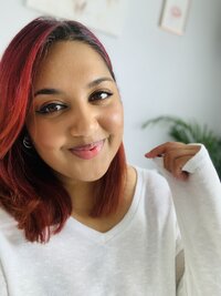 front-facing photo of naaila wearing a cream long sleeved jumper looking into camera