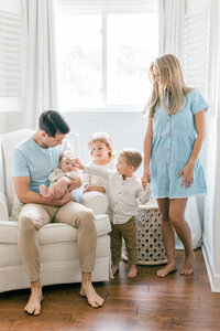 family with newborn baby girl in nursery by Orlando in-home newborn photographer