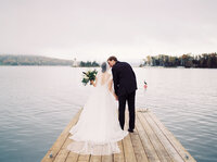 Bride and groom kissing on edge of a jetty in Nova Scotia