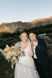 Two brides who just got married showing off their wedding rings