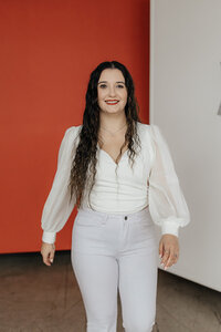 Taysha walking toward the camera smiling wearing an all white outfit.