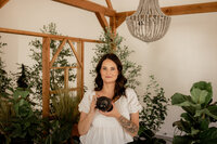 A photographer smiling and holding a camera 