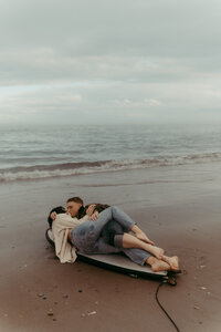 Couple laying on surf board in Topsail Island