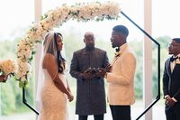 African American Wedding Ceremony under floral arbor